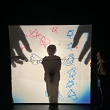 Skyggeteater på scenen. To store hender og skygge av en person.