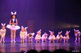 Bilde av barnedans elever på scenen. De er alle utkledd som hvite kaniner. Kaninen fra Alice in Wonderland er også med. Hun holder ei stor klokke. 