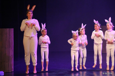 Bilde av barnedans elever på scenen. De er alle utkledd som hvite kaniner. 