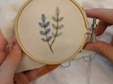 Bildet viser ett broderi av en blomst.