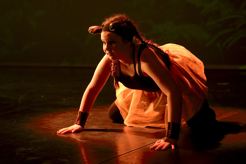 Bildet viser en danser i på senen i rollen som ett dyr med ører og orange strutteskjørt. 